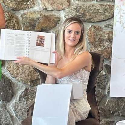 Bride showing off her wedding cookbook at the shower